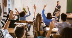 Students all raise hands to participate in effective classroom lecture