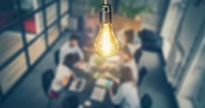 Students collaborate in group with light bulb idea above them
