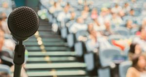Microphone on podium in front of large group of students