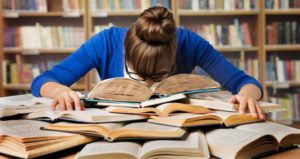 Student surrounded by books and feeling overwhelmed