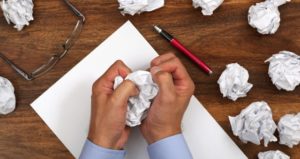 Student crumples paper while writing essay assignment