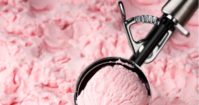 Ice cream scooper scoops strawberry ice cream
