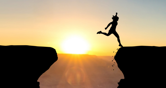Woman jumps over break between cliffs and makes it to the other side