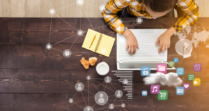 Student sits at desk with computer with icons and activities coming from computer