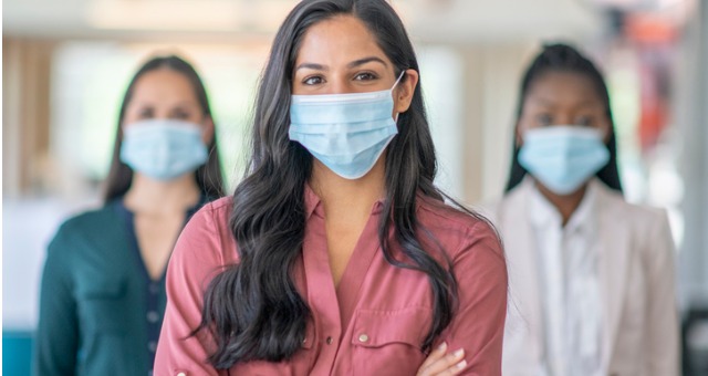 Hispanic and African American students stand with masks and arms crossed