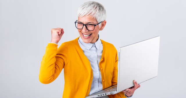 Woman holding computer and cheering for success