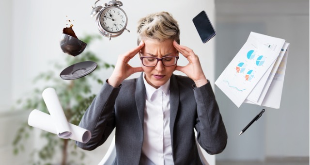 Person has numerous items floating around them with head in hands
