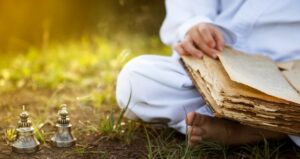 Person meditating and reading ancient script while reading on the ground
