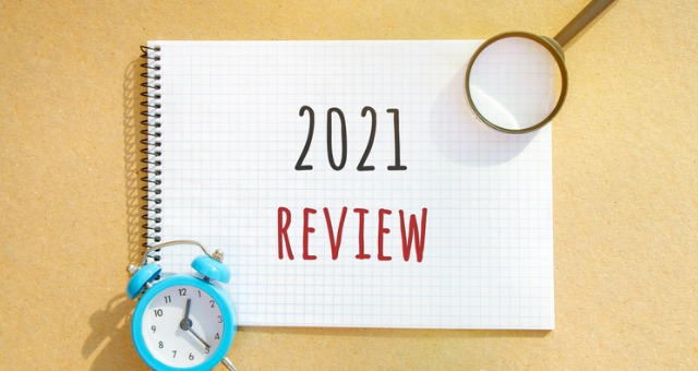 2021 year in review notebook with magnifying glass and clock