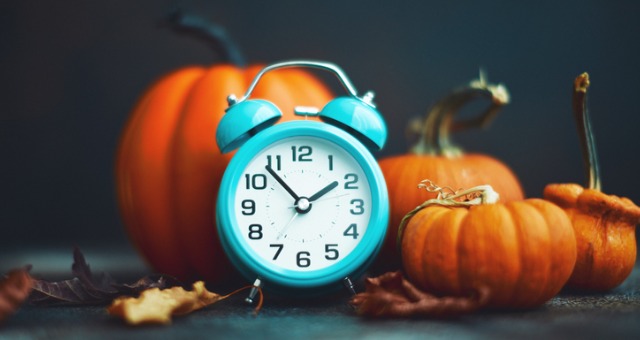 Pumpkins with alarm clock in front of them