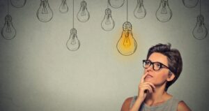Person pondering with lightbulbs hanging