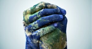 Hands holding together iwith the world painted on the hands