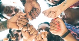Students hold fists together in a unit