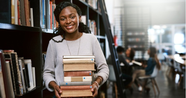 Student holds books in college library