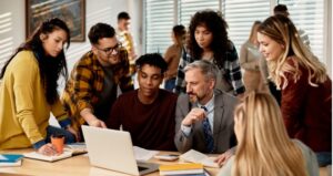 Teacher collaborates with students at desk