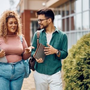 Two students talk and walk with each other to class