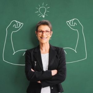 Woman standing in front of chalkboard with muscles drawn on the chalkboard behind her
